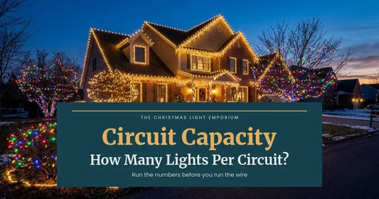 Home with warm white roofline lights and shrubs lit in multicolor lights at dusk. Branded title card from The Christmas Light Emporium reads: Circuit Capacity — How Many Lights Per Circuit?.