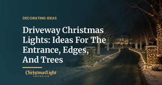 A curving driveway at night in fresh snow, its entrance marked by two stone pillars wrapped in warm white lights, both edges lined with warm white bulbs on ground stakes and bare tree trunks wrapped in lights leading to a glowing house