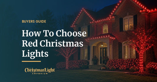 A two-story brick house at night with its roofline and gables outlined in red C9 LED bulbs, front trees wrapped in red mini lights, and shrubs covered in red net lights
