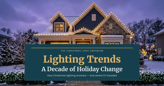 Snowy blue home with warm white roofline lights and lit evergreens at dusk. Branded title card from The Christmas Light Emporium reads: Lighting Trends — A Decade of Holiday Change.