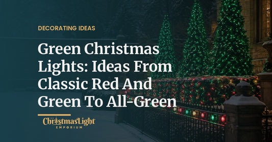 A snowy garden courtyard at night with three tall evergreen trees wrapped in green LED Christmas lights, a hedge covered in red and green net lights, and a wrought-iron fence lined with red and green C9 bulbs
