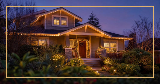 Residential home at twilight with Christmas lights glowing along the roofline and bushes on an automated timer