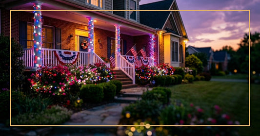 Suburban home at dusk decorated with red, white, and blue LED lights wrapped around porch columns and bushes in a patriotic display