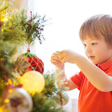 young boy decorating tree
