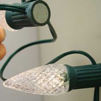Close-up of a green Lite-Netics magnetic C9 socket on SPT1 wire with the magnet base visible