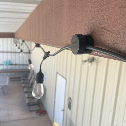 Lite-Netics jumbo magnetic wire clamp holding a light cord under a metal roof edge