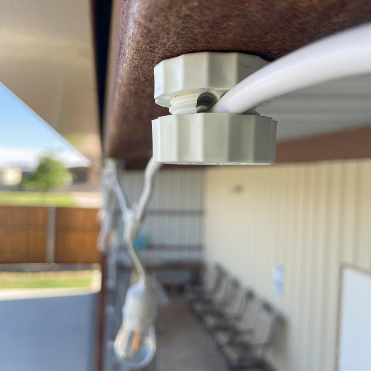 Lite-Netics jumbo magnetic wire clamp routing a light cord along a metal building fascia
