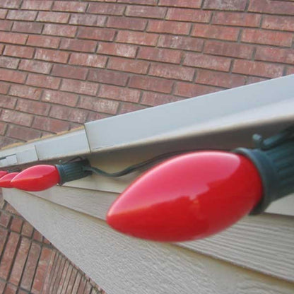 Hand placing a Lite-Netics magnetic C9 socket with warm white LED bulb onto a metal roof edge