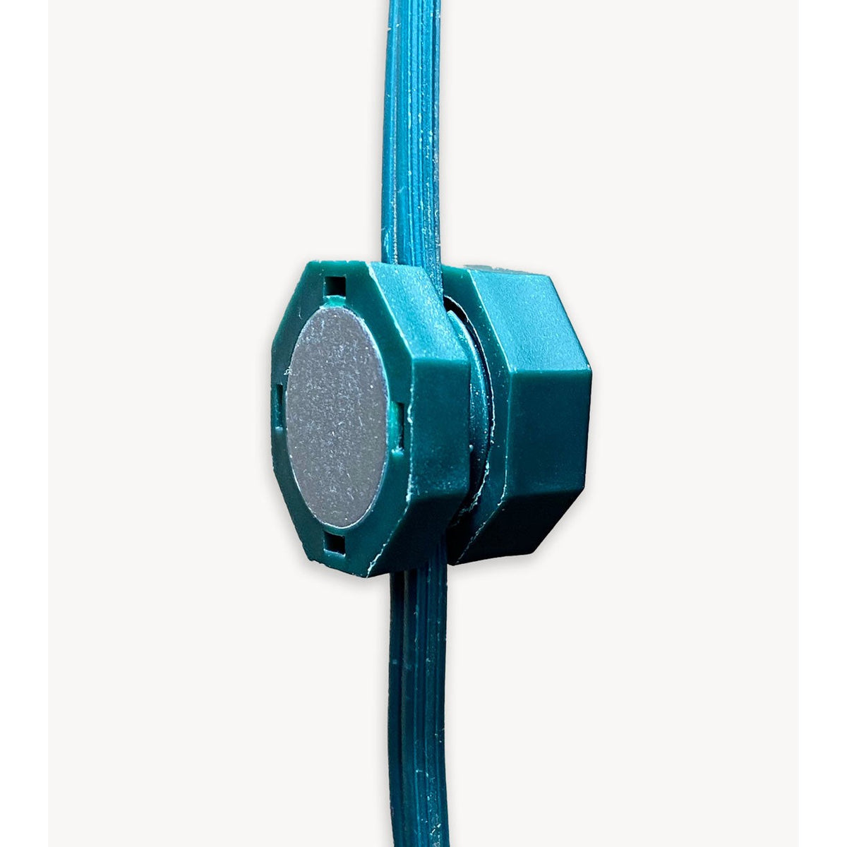 Side view of a green Lite-Netics magnetic wire clamp clamped onto green light-string wire