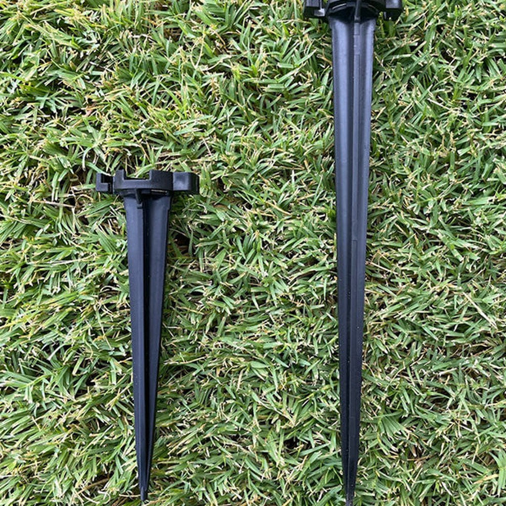 Two black Lite-Netics metal base lawn stakes on grass