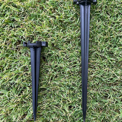 Two black Lite-Netics metal base lawn stakes on grass