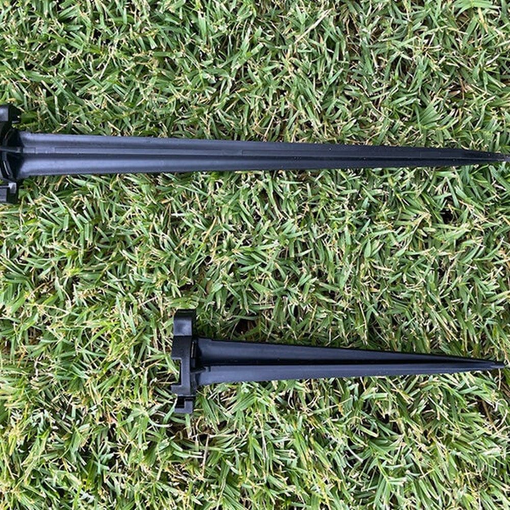 Two black Lite-Netics metal base lawn stakes on grass