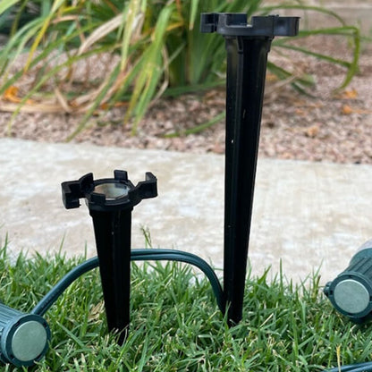 Black Lite-Netics metal base lawn stakes holding C9 light sockets along a lawn